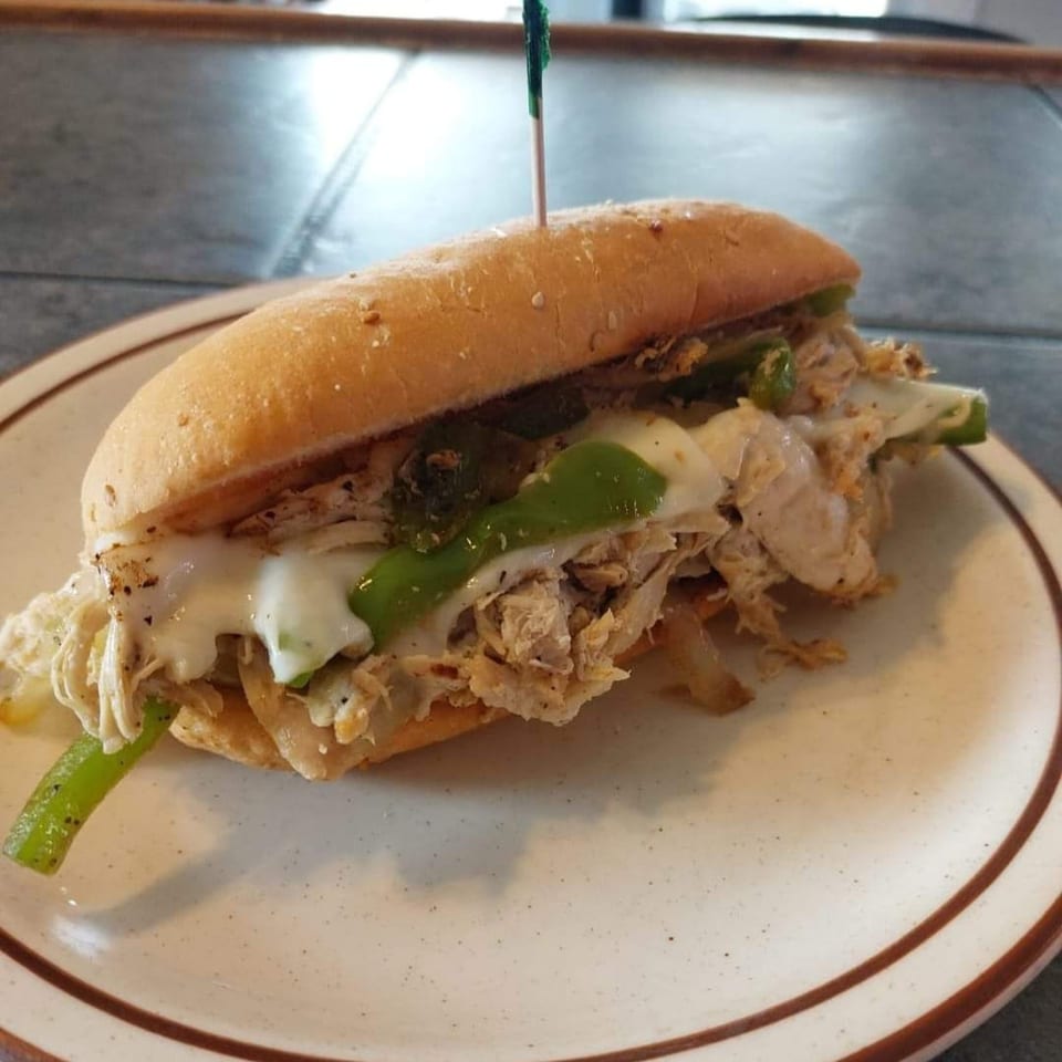 Midway Bar and Grill's chicken cheesesteak with melted cheese and green peppers on a hoagie roll.